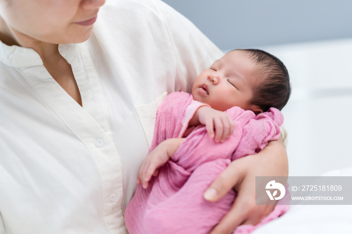 mother holding newborn baby sleeping in arm