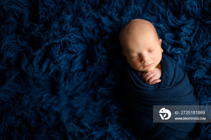 Lovely newborn baby boy sleaping wrapped