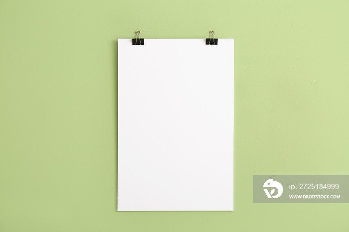 Blank poster hanging on color wall