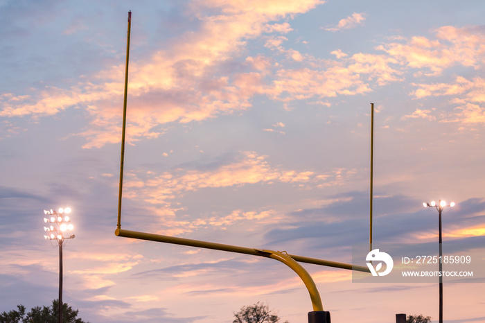 American football goal posts against sunset