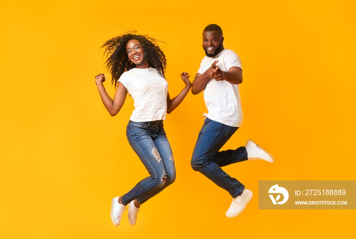 快乐的非洲裔美国夫妇在空中跳跃