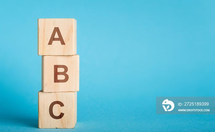 ABC letters of wooden blocks in pillar form on blue background