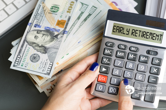 Early retirement decision with stack of money on the table near calculator and alarm clock