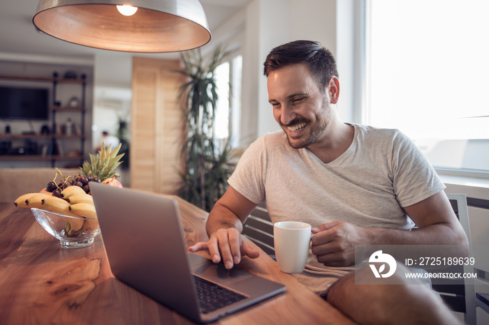 Cheerful  man paying bills at home.E-banking.