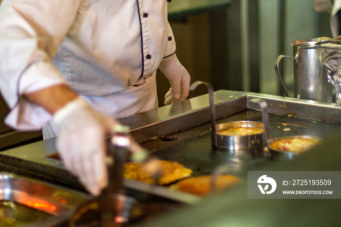 The chef bakes omelettes in the open kitchen of the hotel.