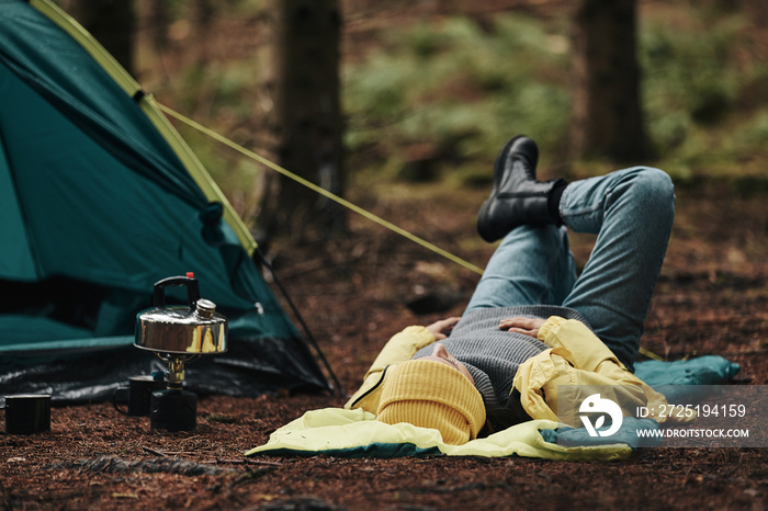 Woman lying on her sleeping bag outdoors