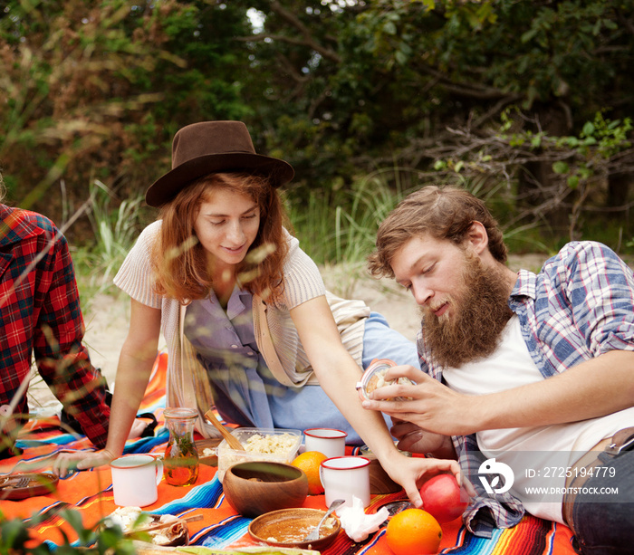 Friends enjoying picnic together in forest