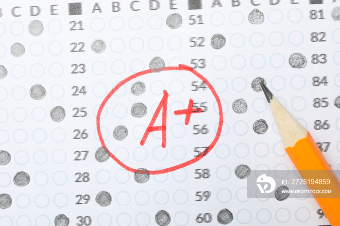 Test score sheet with answers, grade A+ and pencil, close up