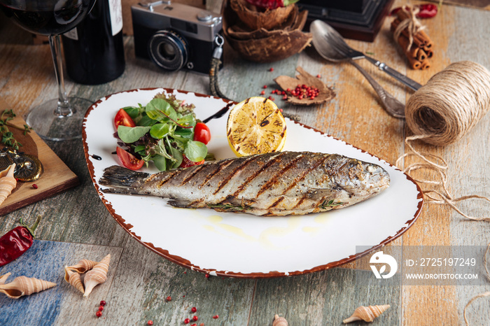 Grilled trout fish with salad and lemon