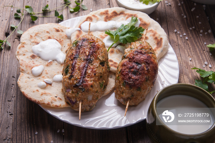 Kofta with flatbread on plate with salad