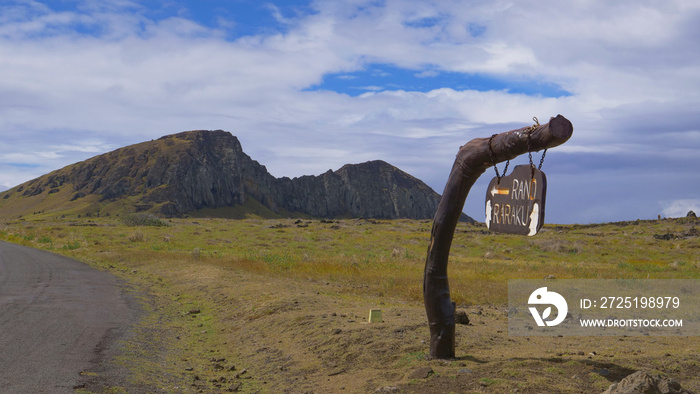 CLOSE UP: Old sign hanging off a stump points towards the Rano Raraku crater.