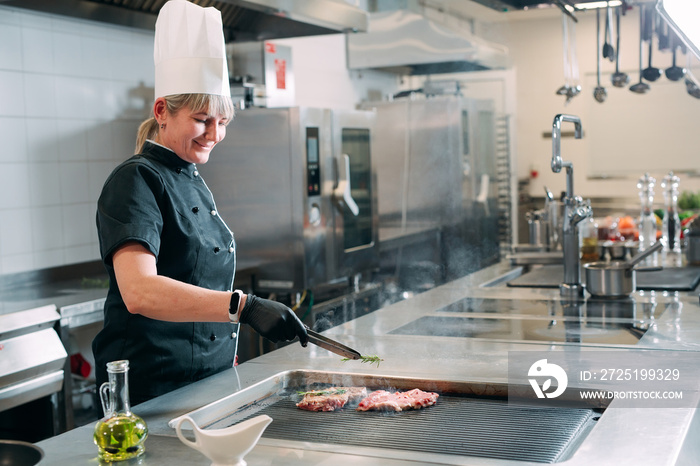 The chef prepares a steak in the restaurants kitchen.