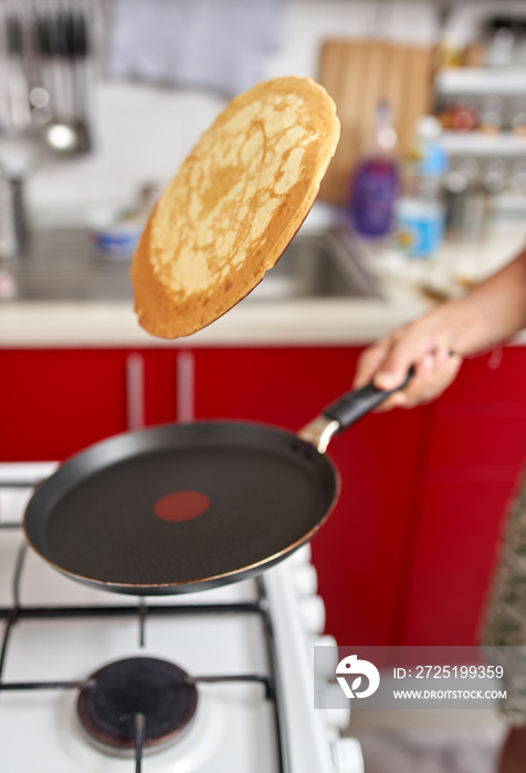 Woman flipping pancake in the pan