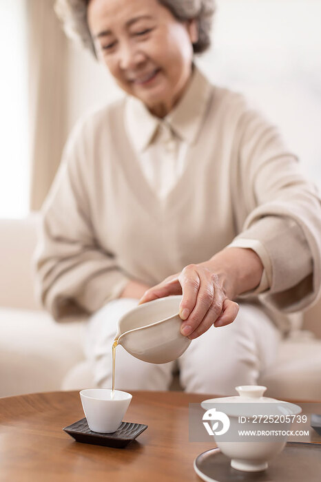 开心的老年女子在家喝茶
