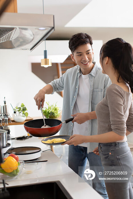 快乐的年轻夫妇在厨房做饭