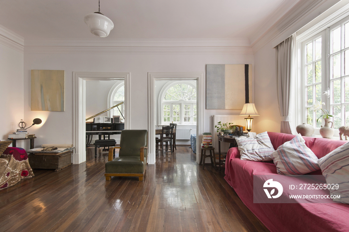 Spacious living room with piano in the neighboring room at home