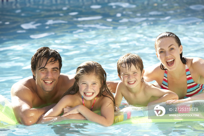 年轻的家庭在游泳池放松