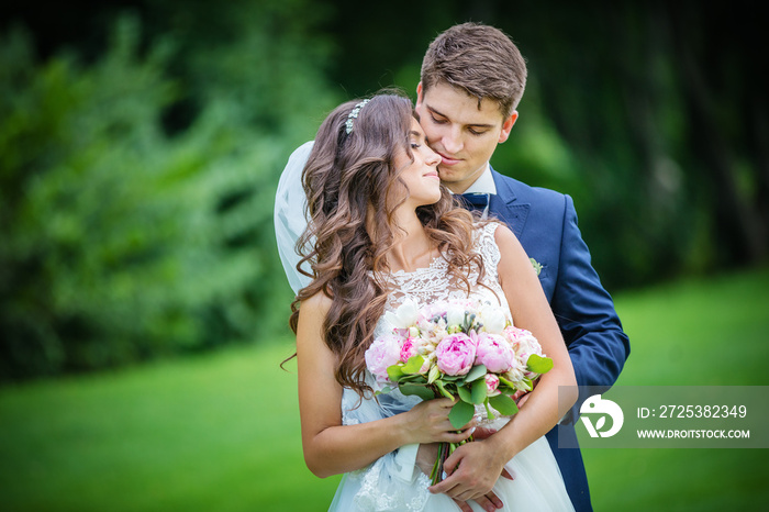 Beautiful young bride and groom in park