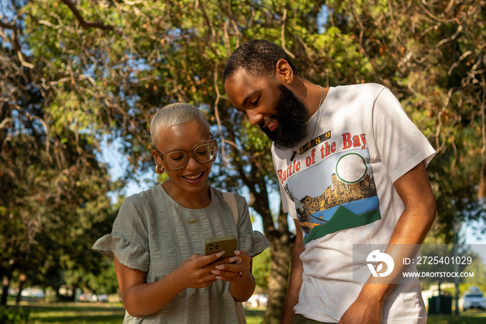 Couple using smart phone in park