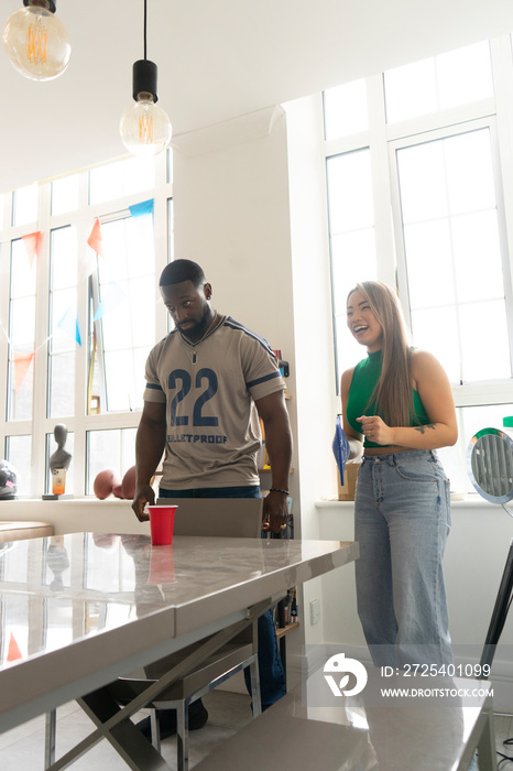 Friends�playing beer pong at home party