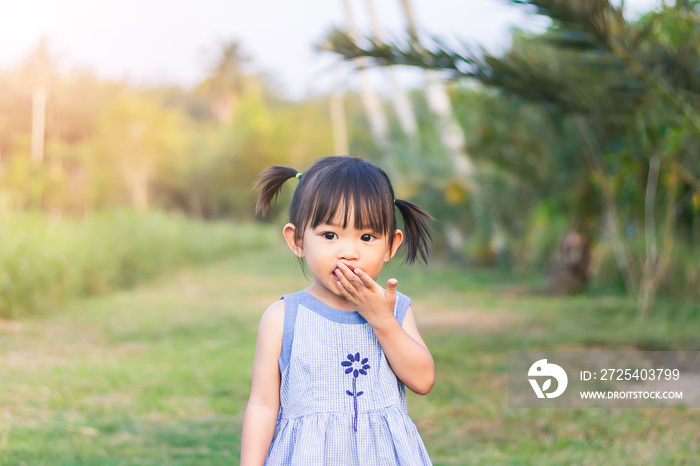 1-2岁婴儿的肖像。一个亚洲女孩把手放进嘴里咬她