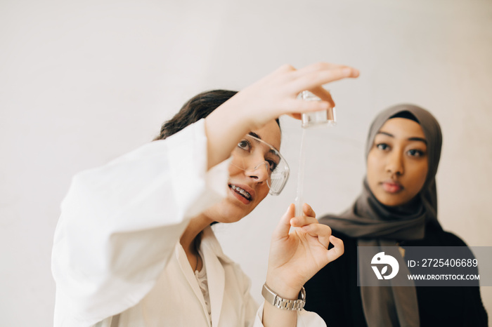 Female students learning scientific experiment during chemistry class