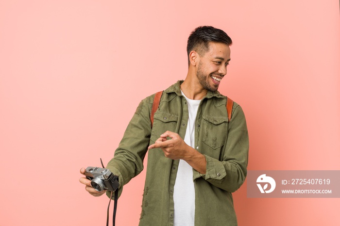 young filipino man holding a retro camera