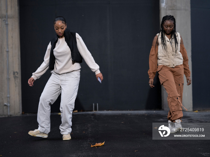 Female friends dancing to hip hop outdoors