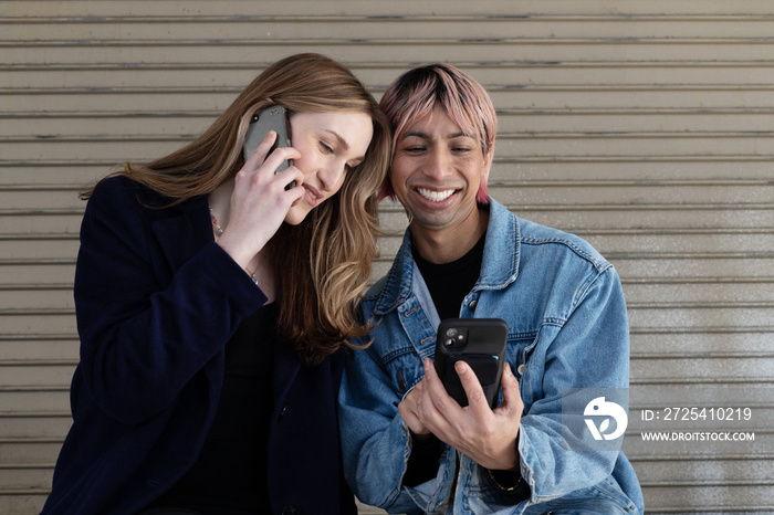 Lgbtqia friends laughing on their phone.