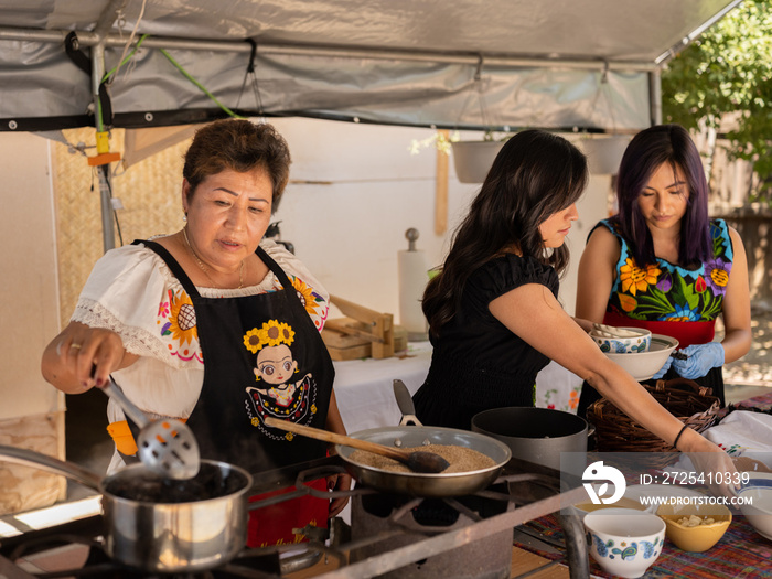 Wide view image of an Indigenous family prepping Indigenous foods