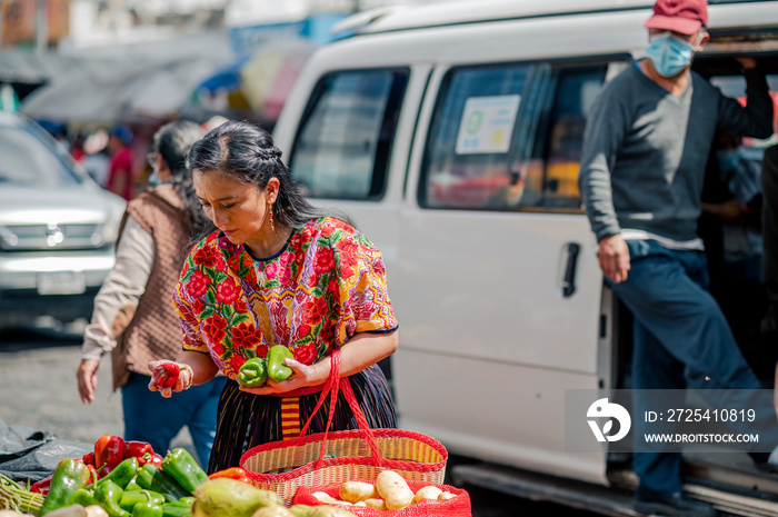 Mujer escoge los vegetales más frescos en en el mercado.