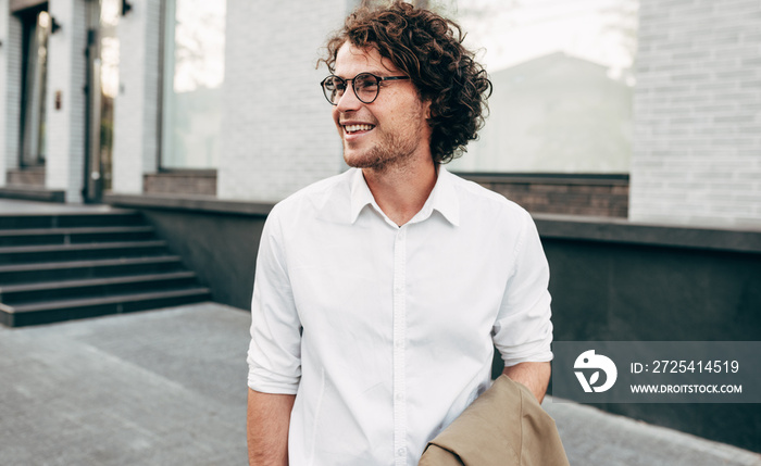 Attractive businessman in eyewear smiling broadly posing outdoors. Male entrepreneur resting in the 