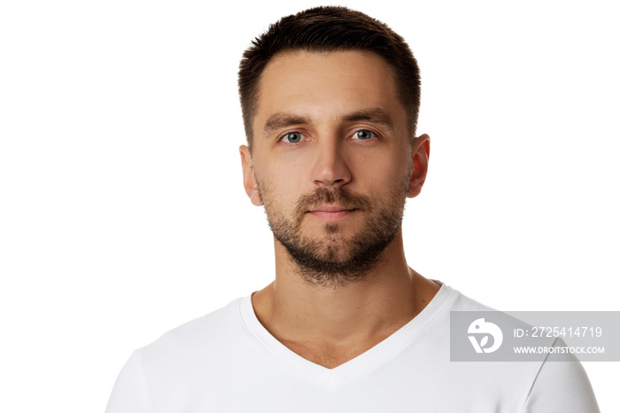 young handsome bearded man in casual white sweater poses in studio on white background