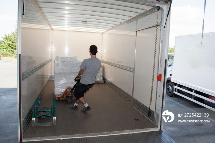 Déchargement de marchandises avec une palette dans la remorque dun camion