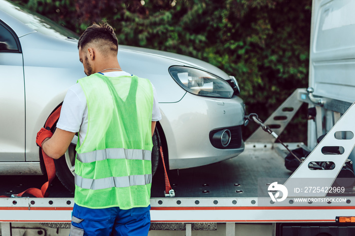 英俊的中年男子在道路上从事牵引服务。路边辅助概念。