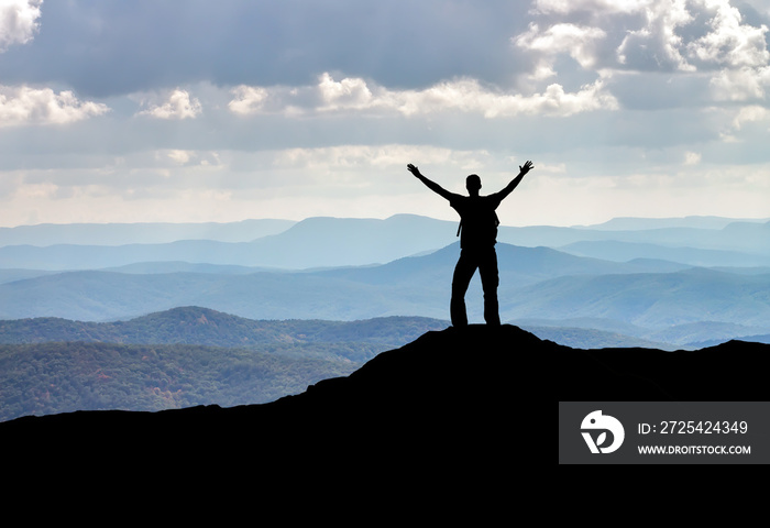 Silhouette of a man on a mountain top. Person on the rock. Sport and active life concept