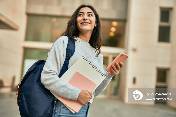 Young middle east student girl smiling happy using smartphone at the city.