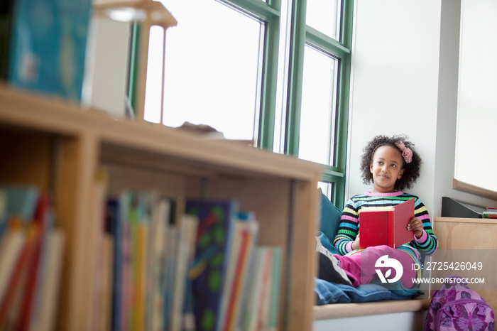 Elementary students reading by window in elementary class