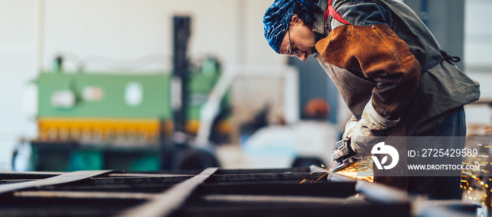 Metal worker using a grinder