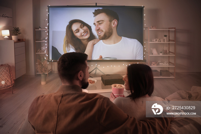Young couple watching movie at home