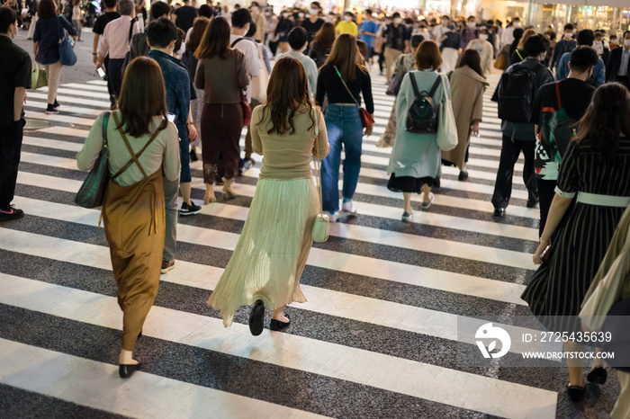 コロナ禍で渋谷スクランブル交差点を歩く若者たち後姿