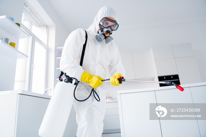 Low angle view photo of focused guy worker hold sprayer latex gloves gas glasses hands spray steam d