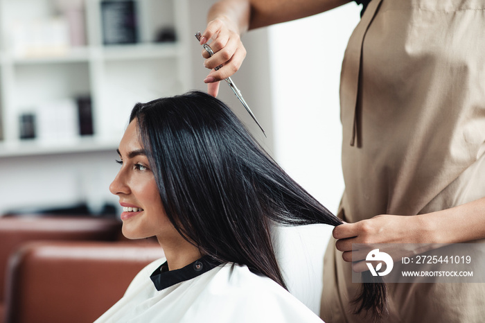 Young brunette woman getting short haircut at hairdressers, close up