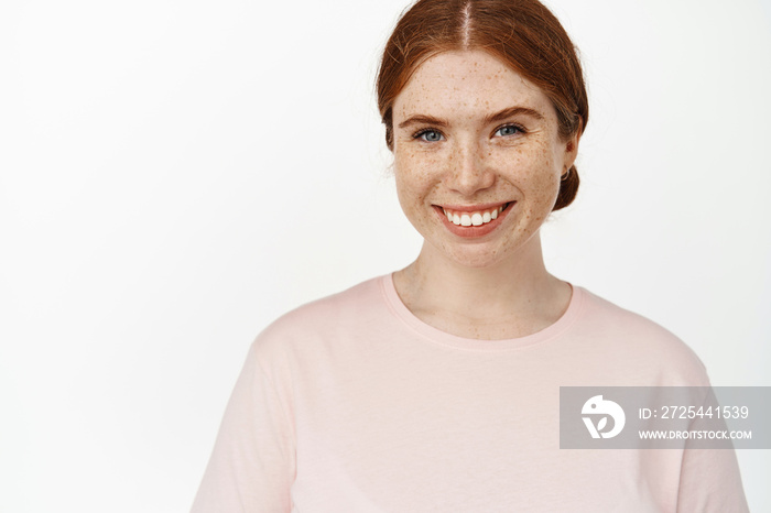 Close up of young ginger girl, caucasian woman with red hair, freckles and white perfect teeth, smil