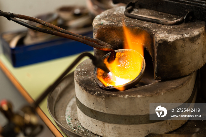 blowtorch melts silver in a jewelry workshop furnace