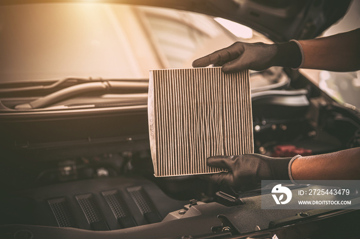 Auto mechanic checking, cleaning and replacing car air filter. Concept of car care service maintenan