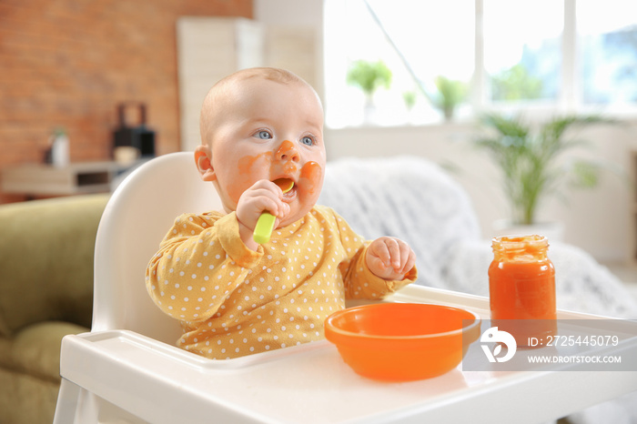 Cute little baby eating tasty food at home