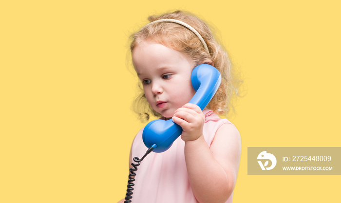 Lovely blonde toddler using vintage telephone