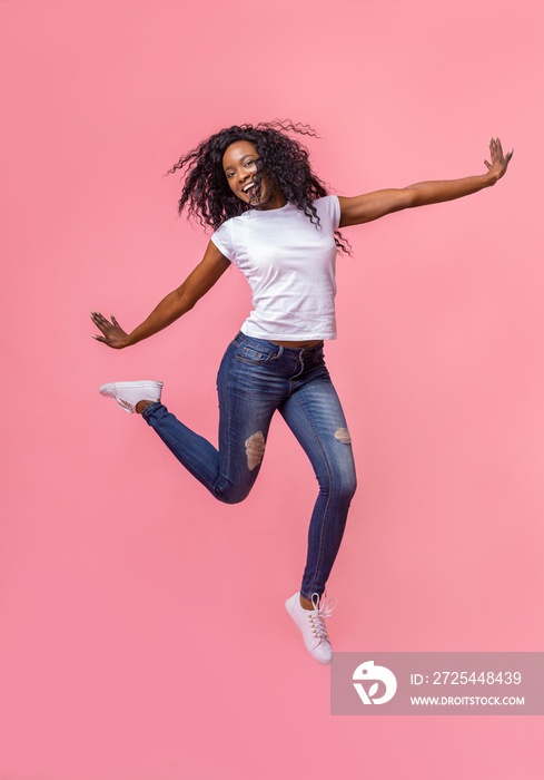 Stunning young girl jumping over pink background