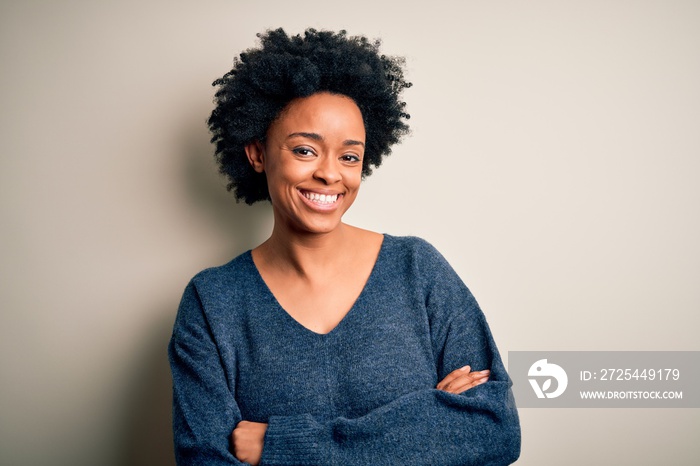 Young beautiful African American afro woman with curly hair wearing casual sweater happy face smilin